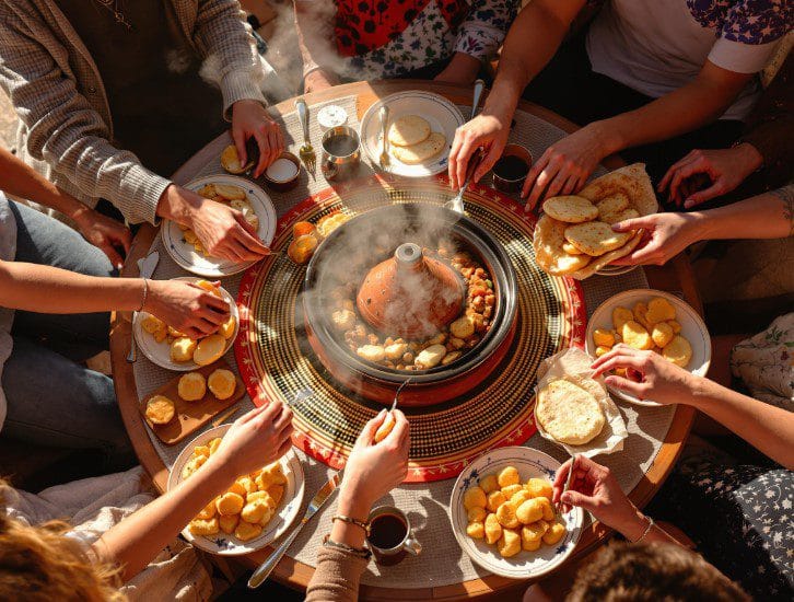Pessoas a partilhar uma tagine tradicional em Marraquexe