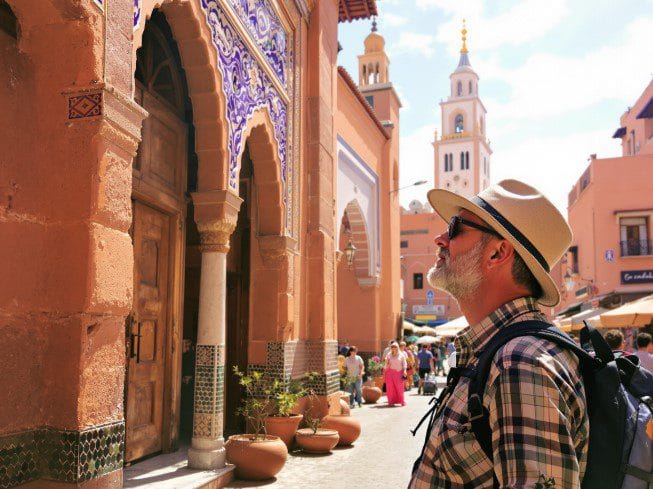 Turista a observar mesquita à distância em Marraquexe